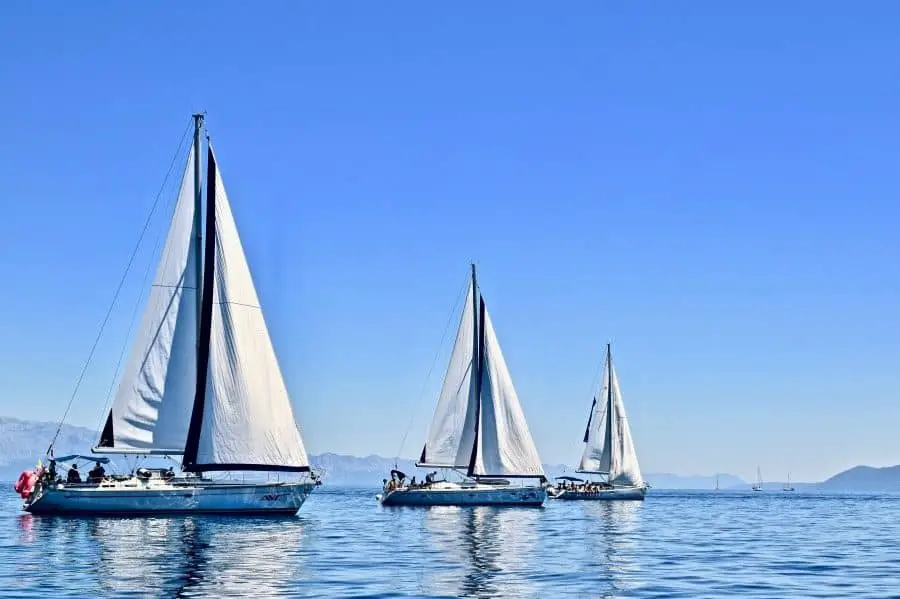 Three sailboats on water