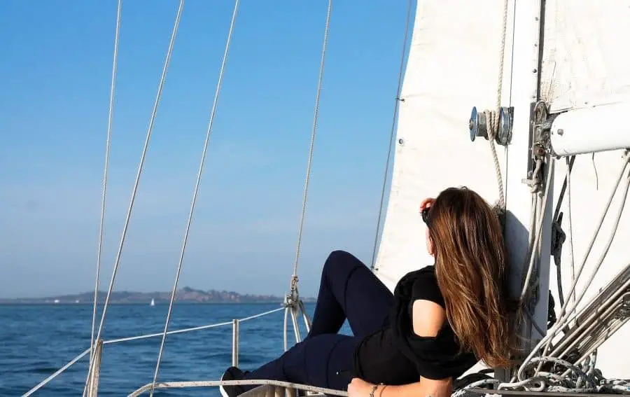 Woman sitting on a sailboat's bow
