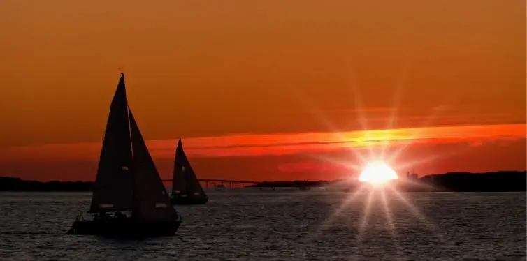Two sailboats racing at sunset